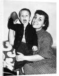Little boy holding football with his mother, ca. 1955 by Anonymous