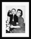 Little boy holding football with his mother, ca. 1955 by Anonymous