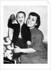 Little boy holding football with his mother, ca. 1955 by Anonymous