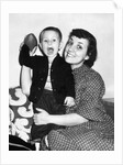 Little boy holding football with his mother, ca. 1955 by Anonymous