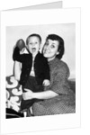 Little boy holding football with his mother, ca. 1955 by Anonymous