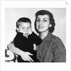 Mother holding son playing peek-a-boo, ca. 1955 by Anonymous
