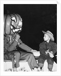 Young boy warily eyes pumpkin man, ca. 1955 by Corbis