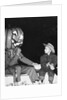 Young boy warily eyes pumpkin man, ca. 1955 by Corbis