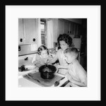 Mom prepares dinner with the kids watching, ca. 1962 by Anonymous