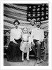 Family pose in front of American Flag, ca. 1898 by Anonymous