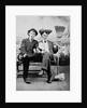 Two young men on a bench with a broom, ca. 1900 by Anonymous
