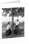 Two women chase each other around a tree, ca. 1910 by Anonymous