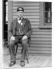 Station master sits at the train depot, ca. 1900. by Anonymous