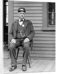 Station master sits at the train depot, ca. 1900. by Anonymous