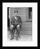 Station master sits at the train depot, ca. 1900. by Anonymous