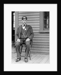 Station master sits at the train depot, ca. 1900. by Anonymous