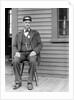 Station master sits at the train depot, ca. 1900. by Anonymous