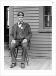 Station master sits at the train depot, ca. 1900. by Anonymous