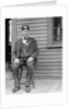 Station master sits at the train depot, ca. 1900. by Anonymous