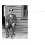 Station master sits at the train depot, ca. 1900. by Anonymous