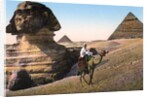 Man riding a camel in front of the Sphinx and pyramids by Anonymous