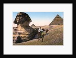 Man riding a camel in front of the Sphinx and pyramids by Anonymous