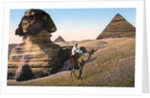 Man riding a camel in front of the Sphinx and pyramids by Anonymous