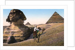 Man riding a camel in front of the Sphinx and pyramids by Anonymous