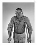 1960s man walking on crutches looking at camera by Anonymous
