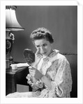 1950s 1960s woman in nightgown holding mirror look at eye wrinkles aging beauty cosmetic serious concerned expression by Anonymous