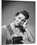 1950s housewife woman in print apron hand up to temple headache pain sad depressed facial expression worried serious looking at camera by Anonymous