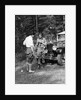 1920s 1930s couple man woman in fishing gear holding poles standing in front of packard touring automobile by Anonymous