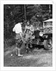 1920s 1930s couple man woman in fishing gear holding poles standing in front of packard touring automobile by Anonymous