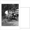 1920s 1930s couple man woman in fishing gear holding poles standing in front of packard touring automobile by Anonymous