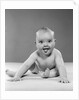 1950s portrait of baby sitting and sticking tongue out looking at camera by Anonymous