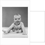 1950s portrait of baby sitting and sticking tongue out looking at camera by Anonymous