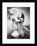 1950s young woman wearing sexy lingerie kneeling on leopard skin holding fluffy dog by Anonymous