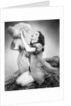 1950s young woman wearing sexy lingerie kneeling on leopard skin holding fluffy dog by Anonymous