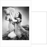 1950s young woman wearing sexy lingerie kneeling on leopard skin holding fluffy dog by Anonymous