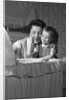 1950s mother & daughter admiring baby in bassinet by Anonymous