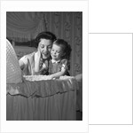1950s mother & daughter admiring baby in bassinet by Anonymous