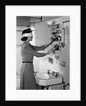 1940s woman wearing blindfold reaching into bathroom medicine cabinet by Anonymous