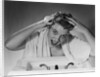 1950s smiling woman washing shampooing hair in sink looking at camera by Anonymous