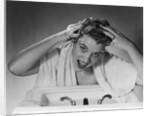 1950s smiling woman washing shampooing hair in sink looking at camera by Anonymous