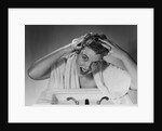 1950s smiling woman washing shampooing hair in sink looking at camera by Anonymous