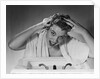 1950s smiling woman washing shampooing hair in sink looking at camera by Anonymous