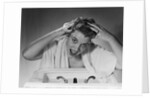 1950s smiling woman washing shampooing hair in sink looking at camera by Anonymous