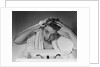 1950s smiling woman washing shampooing hair in sink looking at camera by Anonymous