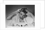 1950s smiling woman washing shampooing hair in sink looking at camera by Anonymous