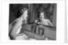 1950s smiling woman looking into bathroom mirror brushing teeth by Anonymous