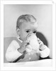 1950s boy toddler drinking glass milk looking at camera by Anonymous