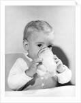 1950s boy toddler drinking glass milk looking at camera by Anonymous