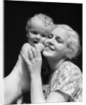 1930s blonde woman mother smiling holding baby to cheek by Anonymous
