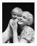 1930s blonde woman mother smiling holding baby to cheek by Anonymous